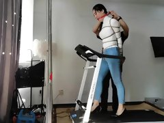 Bound and gagged Asian babe walks on treadmill in high heels