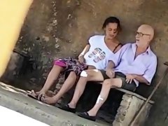 Wild brunette takes an old man's cock for a ride in public